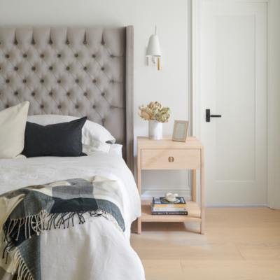 bedroom with wood floors grey headboard and neutral decor